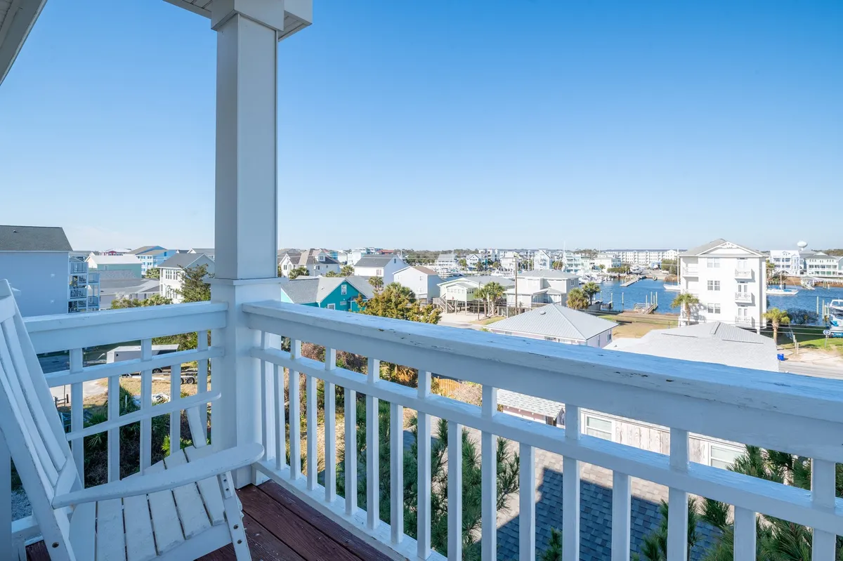 A peaceful balcony with a rocking chair overlooking the water, perfect for enjoying morning coffee, reading, or watching the sunset. The view highlights both marina and ocean elements, inviting relaxation and togetherness.